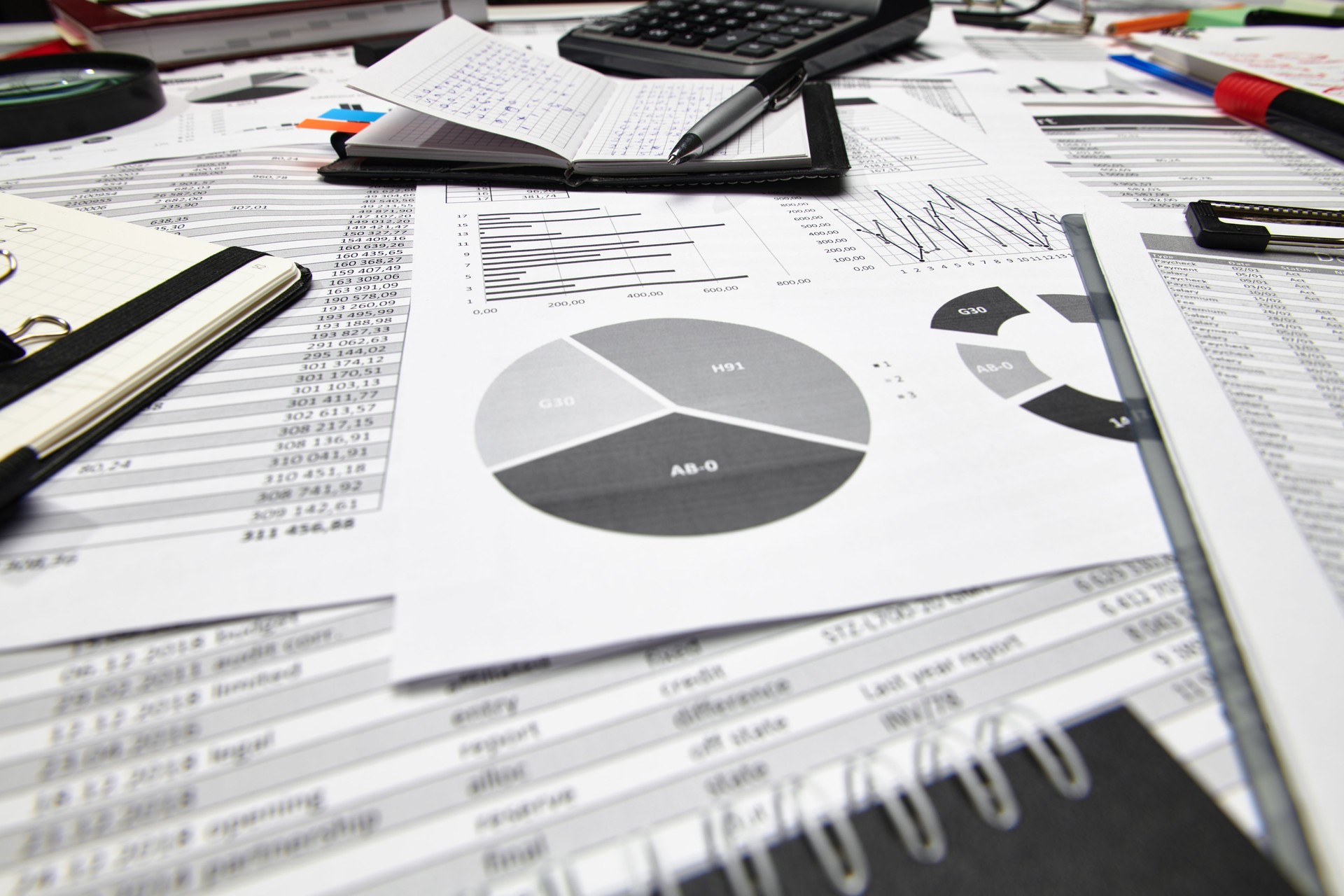 Top view of office employee's desk - work with financial reports, analysis and accounting, tables and graphs, various office items for bookkeeping